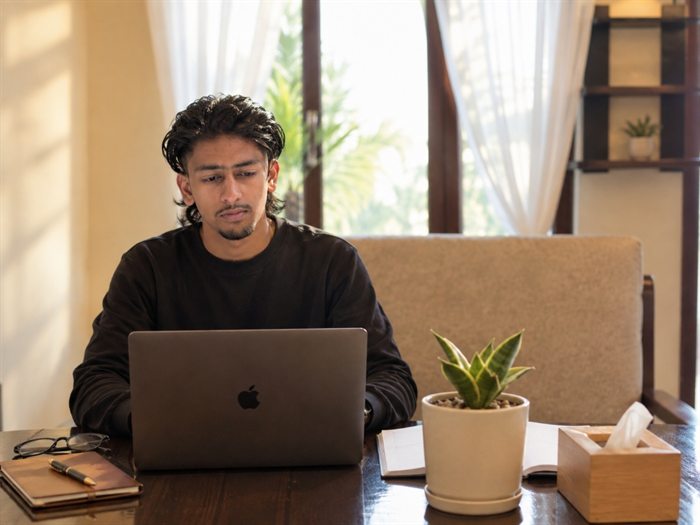 Pranish Poudel working on his laptop